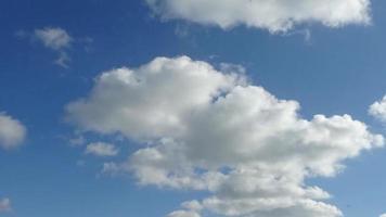 atemberaubender Zeitraffer von Sonnenlicht und sich bewegenden Wolken am blauen Himmel. video