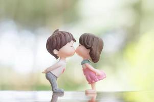 primer plano de mini muñecas de pareja en un beso romántico para el concepto del día de san valentín foto