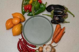 Vegetables are laid out around empty plate. Empty space for text. Vegetables on the table photo