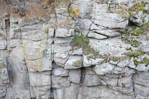 Light coarse natural rock stone background. Mining cliff rough front surface. Big limestone stack backdrop. Heavy grunge damaged granite block texture photo