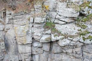 fondo de piedra de roca natural gruesa y clara. superficie frontal rugosa del acantilado minero. gran pila de piedra caliza como telón de fondo. textura de bloque de granito dañado grunge pesado foto