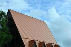 The house is equipped with high-quality roofing of metal tiles. A good example of perfect modern roofing. The building is reliably protected from adverse weather conditions photo