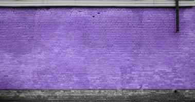 The texture of the brick wall of many rows of bricks painted in violet color photo