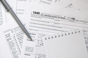 The pen and notebook is lies on the tax form 1040 U.S. Individual Income Tax Return. The time to pay taxes photo