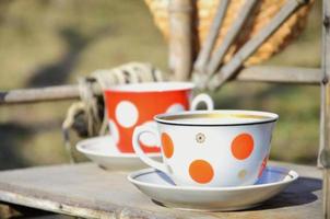 Rustic still life with a cups of tea and straw hat photo