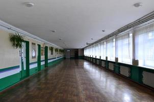 The gloomy corridor of a neglected public building. Public space in a poor residential high-rise building photo