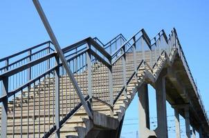 un fragmento de un ascenso escalonado al puente peatonal entre las plataformas de la estación de tren foto