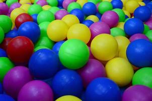 muchas bolas de plástico de colores en una piscina para niños en un parque infantil. patrón de primer plano foto