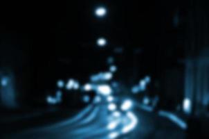 Blurred night scene of traffic on the roadway. Defocused image of cars traveling with luminous headlights. Bokeh Art photo