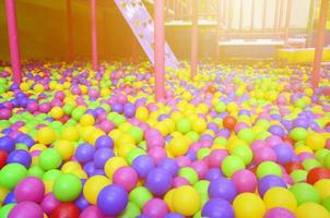 Many colorful plastic balls in a kids' ballpit at a playground photo