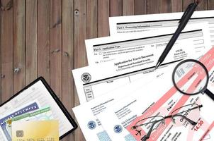 USCIS form I-131 Application for travel document lies on flat lay office table and ready to fill. U.S. Citizenship and Immigration services paperwork concept photo