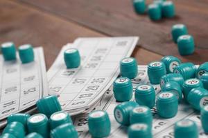 Many barrels with numbers and cards for lotto or russian bingo table game on wooden surface. Russian lotto has similar rules to classical worldwide bingo photo