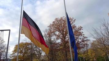 Flagge Deutschlands und der Europäischen Union an einem Fahnenmast, der sich im Wind bewegt. video
