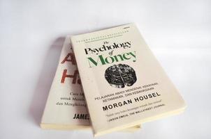 BLITAR, INDONESIA - October 9th 2022 A book The Psychology of Money by Morgan Housel above another book on a white background. photo