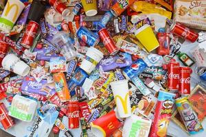 KHARKOV, UKRAINE - JULY 2, 2021 Many wrappings and cans from used products by famous worldwide brands. Pattern of trash of various colors and materials photo