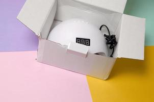 Unboxing of new UV LED nail lamp for curing process by gel method photo