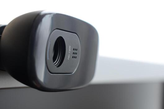 A modern web camera is installed on the body of a flat screen monitor. Device for video communication and recording of high quality video photo