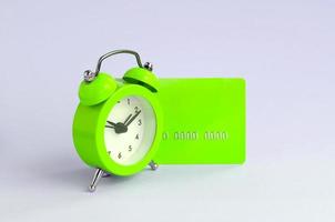 Small green alarm clock and blue credit card photo