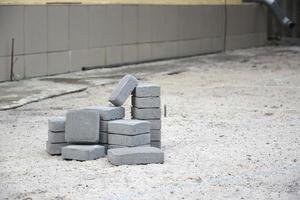 Small pile of gray walkway slabs lying in stack outdoors. Material for Paving Slabs by mosaic in progress. Cobblestone installation photo
