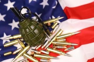 granada de fragmentación f1 y muchas balas y cartuchos amarillos en la bandera de estados unidos. concepto de tráfico de armas en territorio estadounidense o operaciones especiales foto