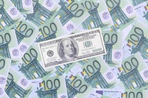 100 dollars bill is lies on a set of green monetary denominations of 100 euros. A lot of money forms an infinite heap photo