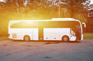 autobús turístico blanco para excursiones. el autobús está estacionado en un estacionamiento cerca del parque foto