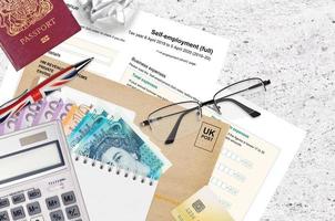 English Tax form sa103 Self-employment from HM revenue and customs lies on table with office items. HMRC paperwork and tax paying process in United Kingdom photo