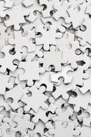 Close-up of a pile of uncompleted elements of a white puzzle. A huge number of rectangular pieces from one large white mosaic photo
