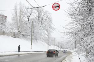 Overtaking is prohibited. The sign prohibits overtaking all vehicles on the road section. A road sign hanging over a snow-covered road photo