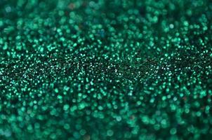 A huge amount of green decorative sequins. Background texture with shiny, small elements that reflect light in a random order. Glitter texture photo