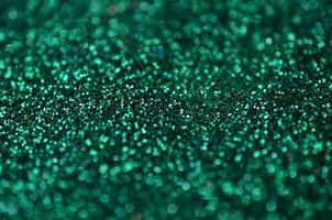 A huge amount of green decorative sequins. Background texture with shiny, small elements that reflect light in a random order. Glitter texture photo