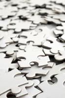 Close-up of a pile of uncompleted elements of a white puzzle. A huge number of rectangular pieces from one large white mosaic photo