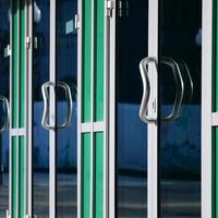 Chrome door handle and glass of modern aluminium office facade photo