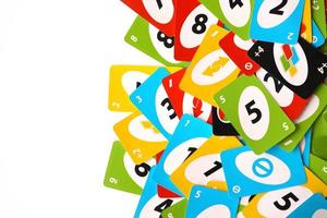 TERNOPIL, UKRAINE - MAY 15, 2022 Many colorful UNO game cards on white background. UNO is an American shedding-type card game that is played with a specially printed deck photo