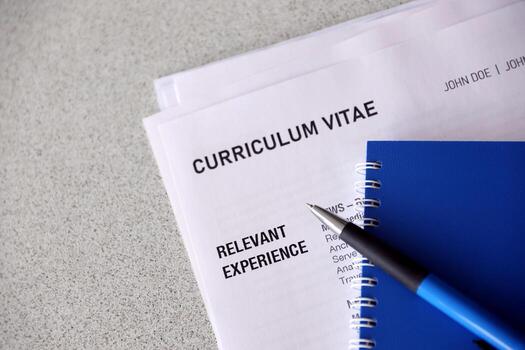 Top view of stack of office documents including resume and cv forms on the desk close to pen and notepad. Job seeking process. Hunting for workplace photo