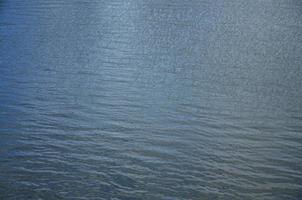 The texture of dark river water under the influence of wind, imprinted in perspective. Horizontal image photo