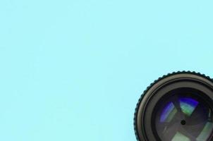 Camera lens with a closed aperture lie on texture background of fashion pastel blue color paper photo