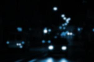 Blurred night scene of traffic on the roadway. Defocused image of cars traveling with luminous headlights. Bokeh Art photo