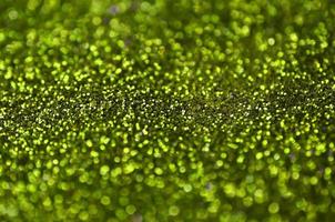 Lime green decorative sequins. Background image with shiny bokeh lights from small elements photo