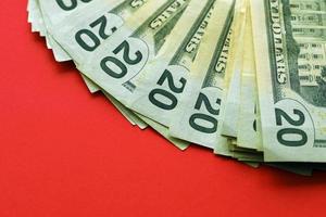 Big amount of old twenty dollar bills on bright red background. Money earnings, payday or tax paying period photo