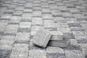 Small pile of gray walkway slabs lying in stack outdoors. Material for Paving Slabs by mosaic in progress. Cobblestone installation photo