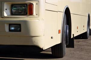 Photo of the hull of a large and long yellow bus. Close-up front view of a passenger vehicle for transportation and tourism