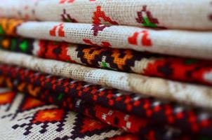 Stack of traditional Ukrainian folk art knitted embroidery patterns on textile fabric photo