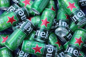 KHARKOV, UKRAINE - JULY 31, 2021 Green tin cans of Heineken lager beer produced by the Dutch brewing company Heineken N.V. photo