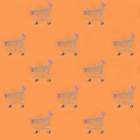 Shopping addiction, shopping lover or shopaholic concept. Many small empty shopping carts perform a pattern on a pastel colored paper background. Flat lay composition, top view photo