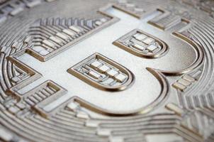 Close up shot of a physical bitcoin with a shiny relief surface made of chocolate. Abstract image of the crypto currency in an edible form photo