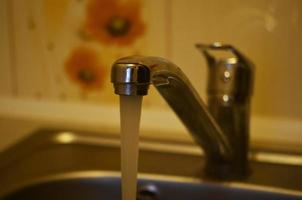 grifo de agua en el fregadero de la cocina foto