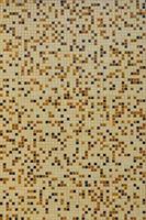 The texture of the wall, decorated with a mosaic of various small square tiles. Abstract pattern of ceramic tiles on the wall photo