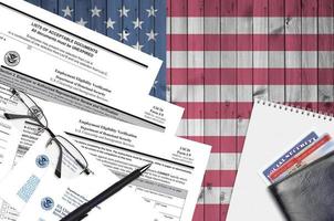 USCIS form I-9 Employment eligibility verification lies on flat lay office table and ready to fill. U.S. Citizenship and Immigration services paperwork concept photo