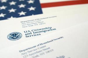 Envelopes with letter from USCIS on United States flag from Department of Homeland Security photo